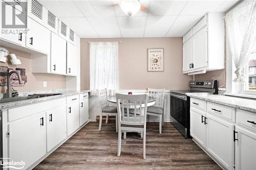 Kitchen with white cabinetry, stainless steel electric range oven, and sink - 97 William Street, Parry Sound, ON - Indoor Photo Showing Kitchen