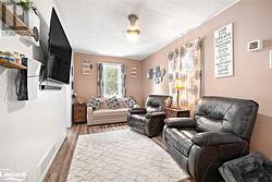 Living room with dark hardwood / wood-style flooring and crown molding - 