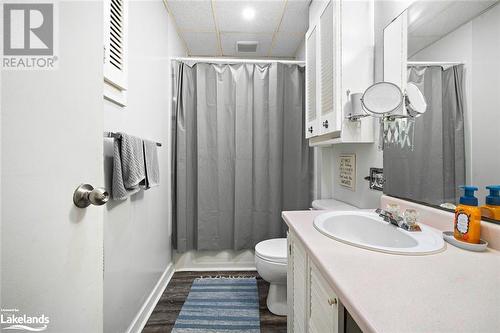 Full bathroom featuring a drop ceiling, shower / bath combo, wood-type flooring, toilet, and vanity - 97 William Street, Parry Sound, ON - Indoor Photo Showing Bathroom