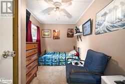 Carpeted bedroom featuring ceiling fan and crown molding - 