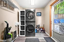 Washroom featuring hardwood / wood-style floors and stacked washer / dryer - 