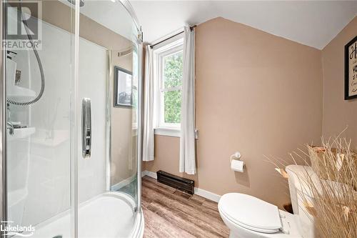 Bathroom with toilet, hardwood / wood-style floors, vaulted ceiling, and a shower with shower door - 97 William Street, Parry Sound, ON - Indoor Photo Showing Bathroom