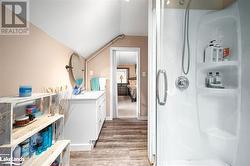 Bathroom with walk in shower, wood-type flooring, vanity, and lofted ceiling - 