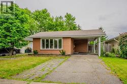 View of front of home featuring a front yard and a carport - 