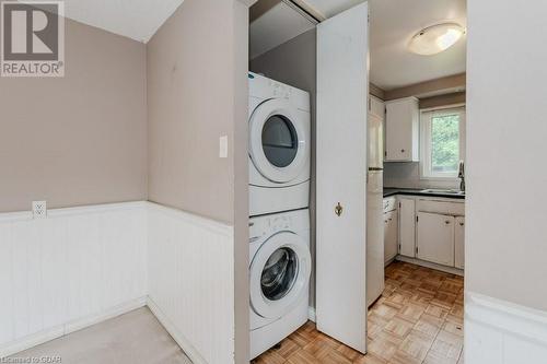 Washroom featuring light parquet flooring, sink, and stacked washer and clothes dryer - 46 Appalachian Crescent, Kitchener, ON - Indoor Photo Showing Laundry Room