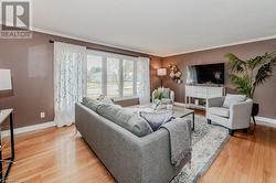 Living room featuring ornamental molding and light hardwood / wood-style flooring - 