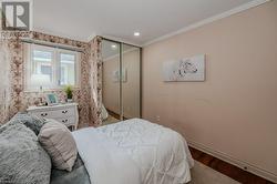 Bedroom featuring a closet, hardwood / wood-style floors, and crown molding - 