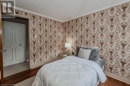 Bedroom with dark wood-type flooring, a textured ceiling, a closet, and crown molding - 46 Appalachian Crescent, Kitchener, ON - Indoor Photo Showing Bedroom