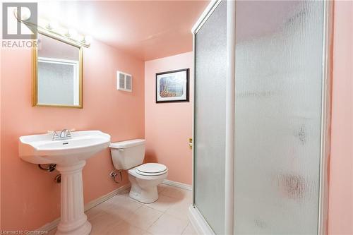 Bathroom featuring walk in shower, tile patterned flooring, toilet, and sink - 46 Mark Place, Hamilton, ON 