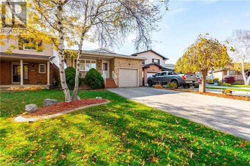 View of front facade with a garage, covered porch, and a front yard - 46 Mark Place, Hamilton, ON 