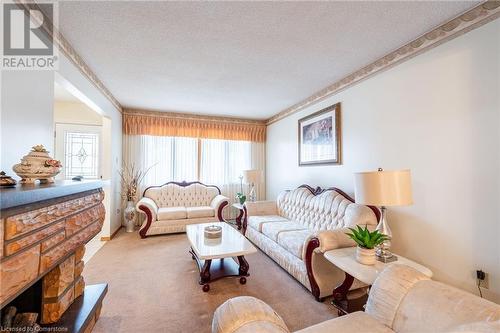 Carpeted living room with a textured ceiling and crown molding - 46 Mark Place, Hamilton, ON 