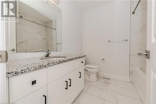 Full bathroom featuring vanity, tiled shower / bath combo, and toilet - 1023 Devonshire Avenue Unit# 3, Woodstock, ON - Indoor Photo Showing Bathroom