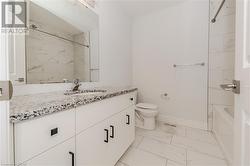 Full bathroom featuring vanity, tiled shower / bath combo, and toilet - 