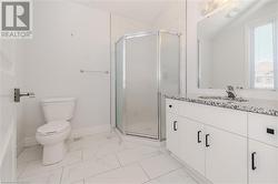 Bathroom featuring vanity, toilet, and a shower with shower door - 