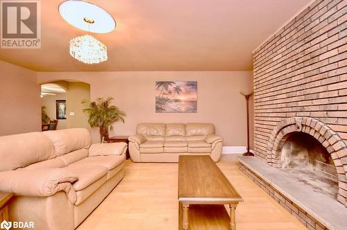 Living room with a notable chandelier, a brick fireplace, and light hardwood / wood-style flooring - 264 Salem Road, Barrie, ON 