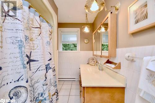 Bathroom featuring tile walls, tile patterned floors, walk in shower, vanity, and baseboard heating - 264 Salem Road, Barrie, ON 