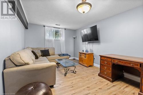 Living room with light wood-type flooring and a textured ceiling - 253 Auden Road, Guelph, ON - Indoor