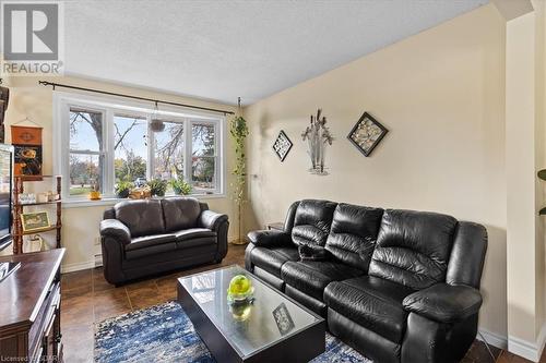 Tiled living room with baseboard heating and a textured ceiling - 253 Auden Road, Guelph, ON - Indoor Photo Showing Living Room