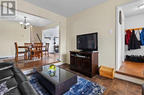 Living room featuring an inviting chandelier, dark tile patterned floors, and a textured ceiling - 253 Auden Road, Guelph, ON - Indoor Photo Showing Living Room