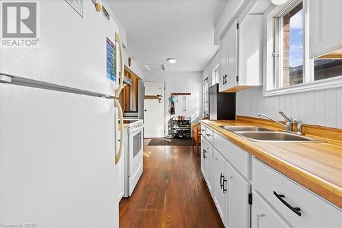 Kitchen featuring white cabinetry, dark wood-type flooring, sink, and white appliances - 253 Auden Road, Guelph, ON - Indoor Photo Showing Kitchen With Double Sink