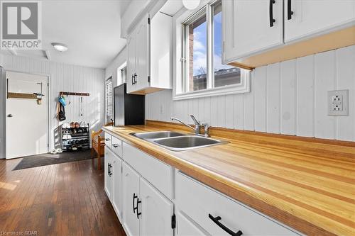 Kitchen with dark hardwood / wood-style flooring, sink, and white cabinets - 253 Auden Road, Guelph, ON - Indoor Photo Showing Kitchen With Double Sink