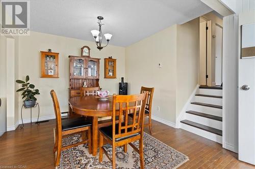 Dining area with dark hardwood / wood-style flooring, a textured ceiling, and an inviting chandelier - 253 Auden Road, Guelph, ON - Indoor Photo Showing Dining Room