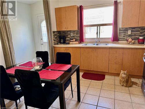 Kitchen featuring decorative backsplash, sink, and light tile patterned flooring - 21 Minto Avenue, Hamilton, ON 