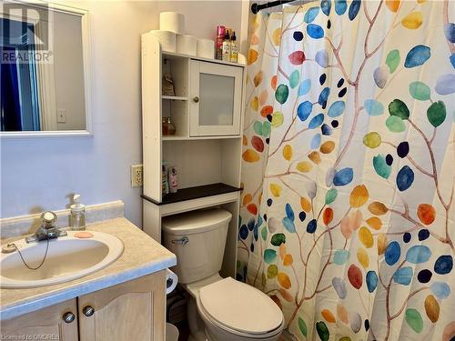 Bathroom featuring a shower with shower curtain, vanity, and toilet - 21 Minto Avenue, Hamilton, ON 