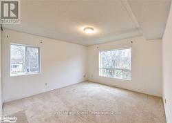 Spare room with a healthy amount of sunlight, light carpet, and a textured ceiling - 