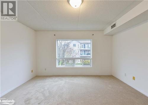 Carpeted spare room featuring a textured ceiling - 107 Bond Street Unit# 201, Orillia, ON - Indoor Photo Showing Other Room