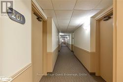 Corridor with a drop ceiling and carpet flooring - 