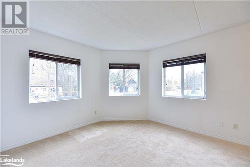 Carpeted empty room featuring a textured ceiling and a healthy amount of sunlight - 107 Bond Street Unit# 201, Orillia, ON - Indoor Photo Showing Other Room