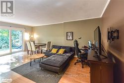 Living room with light hardwood / wood-style floors, a textured ceiling, and crown molding - 