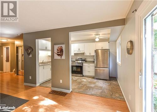 Kitchen with white cabinets, decorative backsplash, light hardwood / wood-style floors, and stainless steel appliances - 441 Barrie Road Unit# 34, Orillia, ON - Indoor