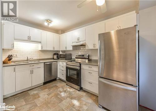 Kitchen with sink, appliances with stainless steel finishes, ceiling fan, backsplash, and white cabinets - 441 Barrie Road Unit# 34, Orillia, ON - Indoor Photo Showing Kitchen With Double Sink