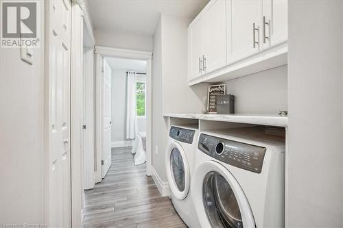 Clothes washing area with washing machine and dryer, cabinets, and light wood-type flooring - 130 Livingston Avenue Unit# 21, Grimsby, ON - Indoor Photo Showing Laundry Room