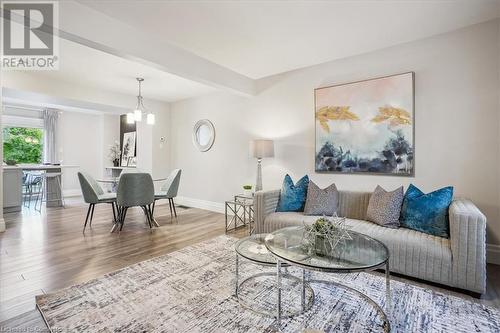 Living room with beamed ceiling, a chandelier, and hardwood / wood-style floors - 130 Livingston Avenue Unit# 21, Grimsby, ON - Indoor Photo Showing Living Room