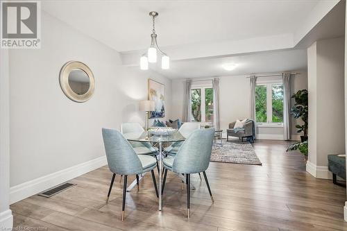 Dining space featuring hardwood / wood-style flooring and an inviting chandelier - 130 Livingston Avenue Unit# 21, Grimsby, ON - Indoor Photo Showing Dining Room