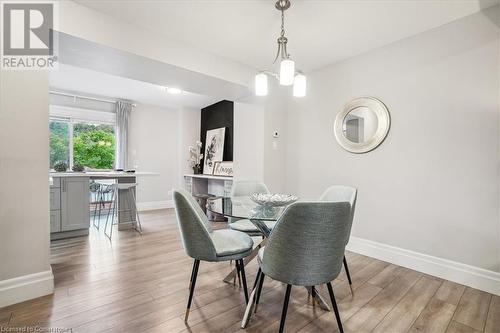 Dining room with light hardwood / wood-style flooring and a notable chandelier - 130 Livingston Avenue Unit# 21, Grimsby, ON - Indoor Photo Showing Dining Room