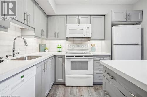 Kitchen with gray cabinetry, light wood-type flooring, white appliances, and sink - 130 Livingston Avenue Unit# 21, Grimsby, ON - Indoor Photo Showing Kitchen