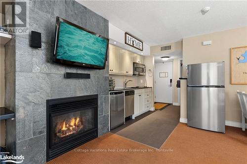 52-107 - 1235 Deerhurst Drive, Huntsville (Chaffey), ON - Indoor Photo Showing Kitchen With Fireplace