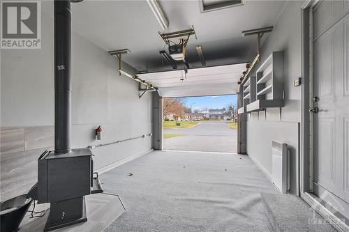 Garage with wood stove - 225 Twelfth Street E, Cornwall, ON - Indoor Photo Showing Garage