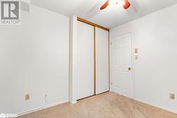 Unfurnished bedroom with a textured ceiling, light carpet, ceiling fan, and a closet - 