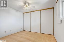 Unfurnished bedroom with a textured ceiling, light carpet, ceiling fan, and a closet - 