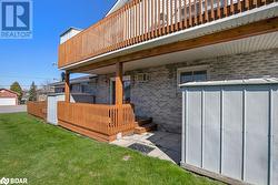 Rear view of house with a wall mounted AC, a yard, and a deck - 