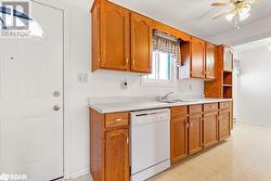 Kitchen featuring ceiling fan, sink, and white dishwasher - 