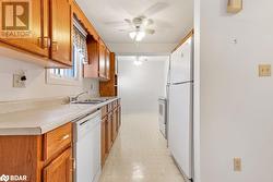 Kitchen with white appliances, sink, and ceiling fan - 