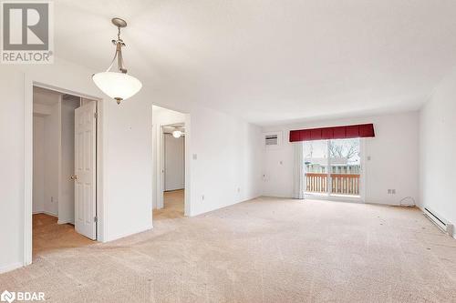 Carpeted spare room featuring ceiling fan, baseboard heating, and a wall mounted AC - 73 Lywood Street Unit# 2, Belleville, ON - Indoor