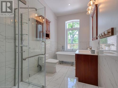 Full bathroom featuring vanity, toilet, tile walls, and shower with separate bathtub - 151 Thames Street S, Ingersoll, ON 