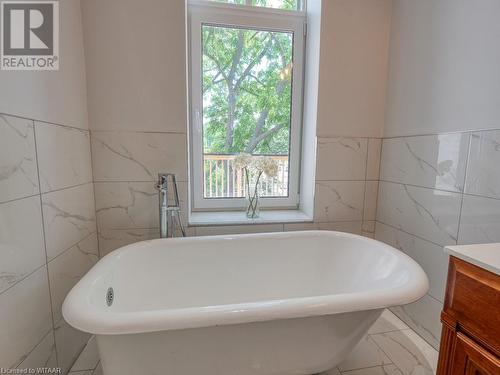 Bathroom with vanity, tile walls, and a tub - 151 Thames Street S, Ingersoll, ON 